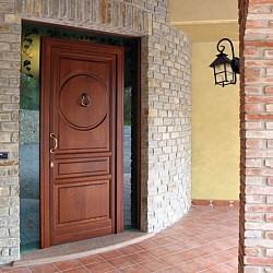 Portone ad un'anta con pannello bugnato.