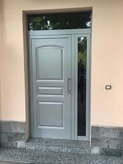 Portone a due ante con pannello bugnato e vetro.